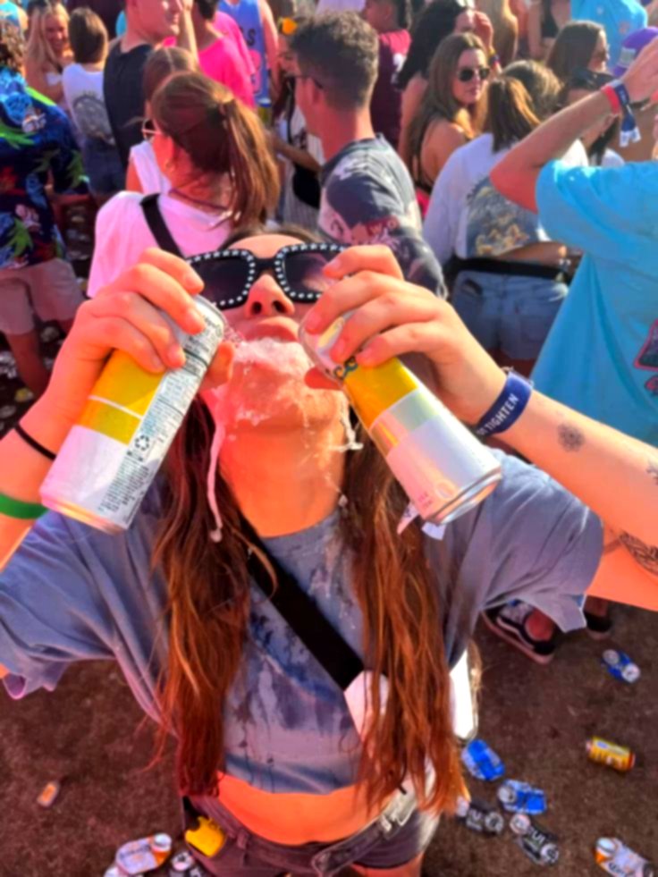 Un asistente a la fiesta con latas en la mano entre la multitud
