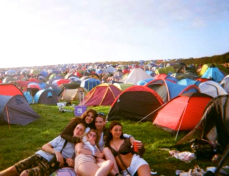 Un grupo de amigos delante de sus tiendas de campaña en el camping del festival