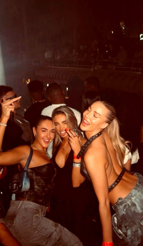 Tres amigas en la oscuridad en un festival, foto con flash